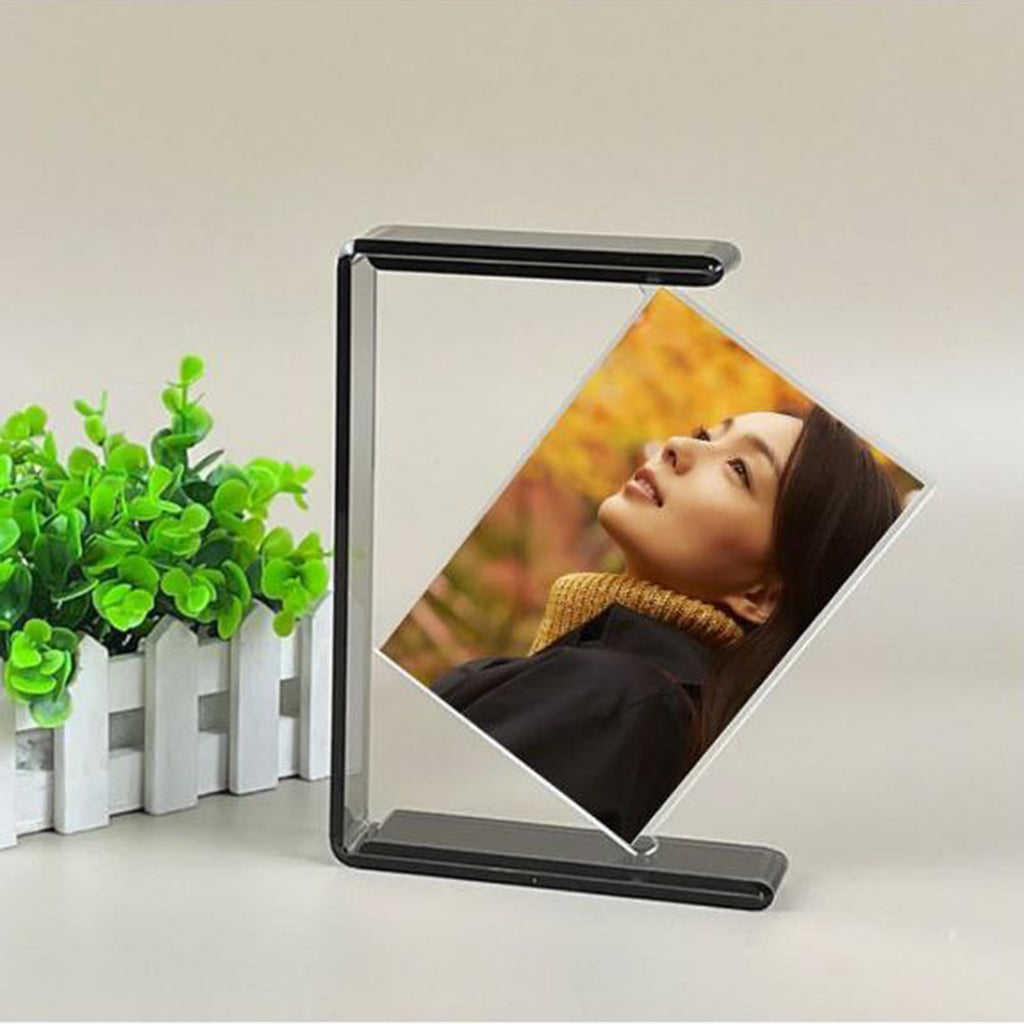Foldable photo frame displaying a person with a blurred background on a white surface with a plant.